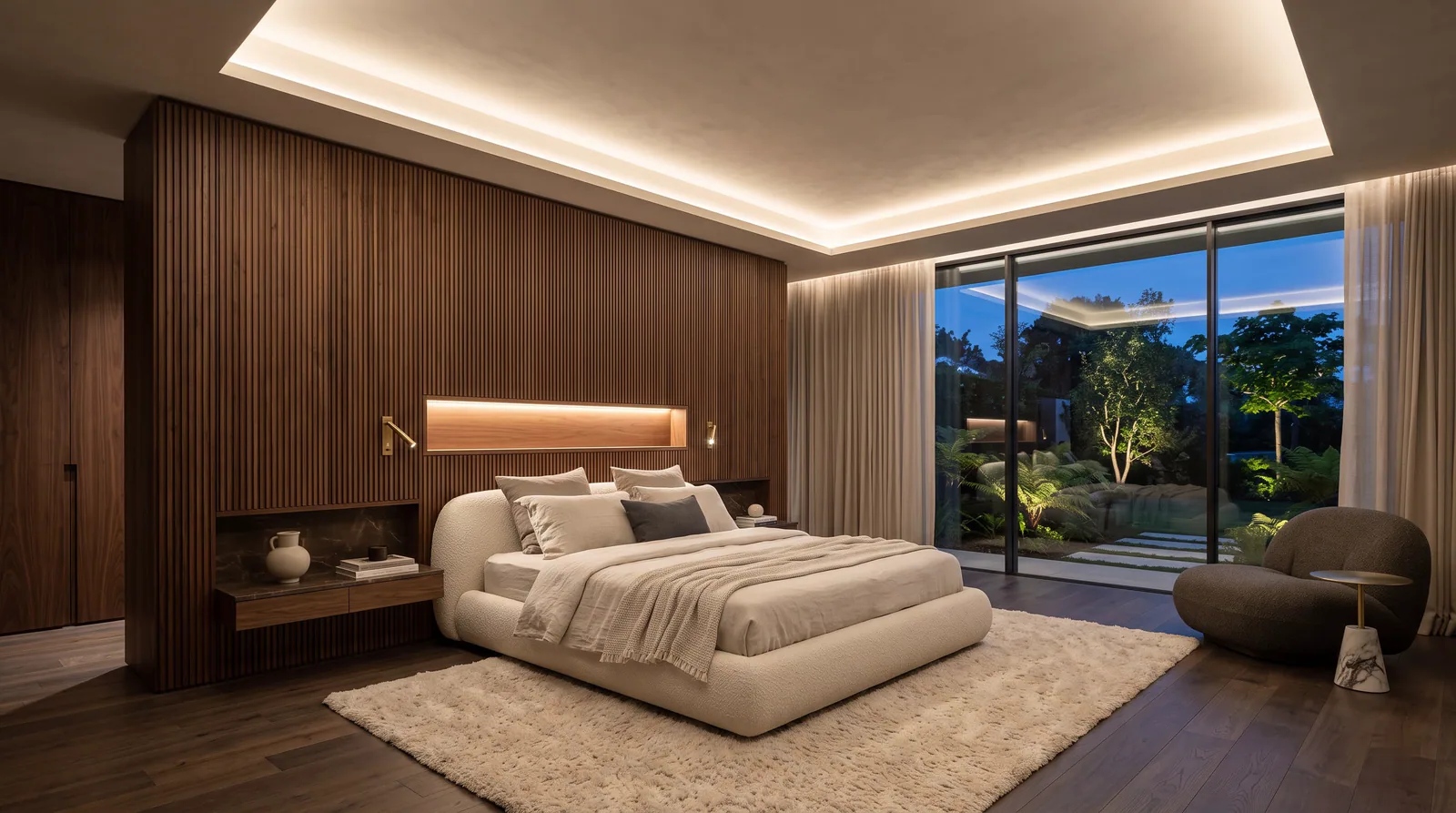 Master bedroom suite with a fluted walnut headboard wall, a lounge corner and a garden view at dusk